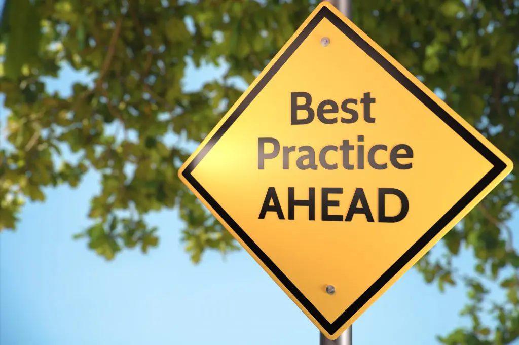 Yellow road sign reading “Best Practice Ahead”